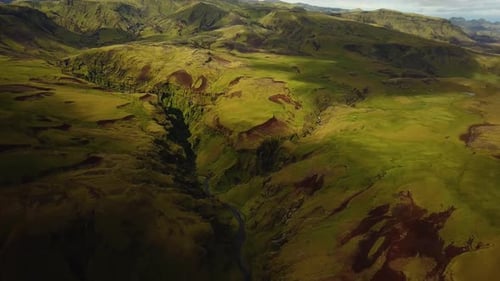 Aerial landscape view of a river flowing in a mountain canyon, in Iceland