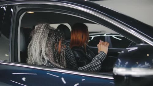 Two Happy Women Dancing Inside New Car