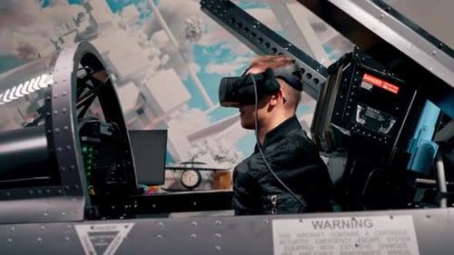 guy sitting in flight simulator of military plane wearing virtual reality glasses during flight