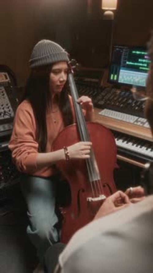 Vertical Girl Playing Cello in Recording Studio with Music Producer