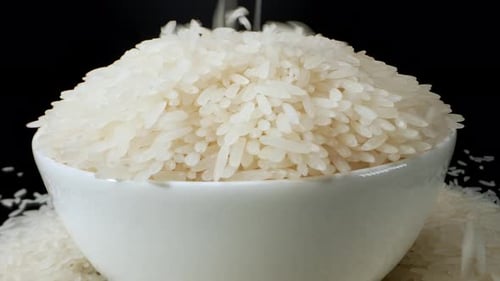 Pouring jasmine rice on the bowl in macro video