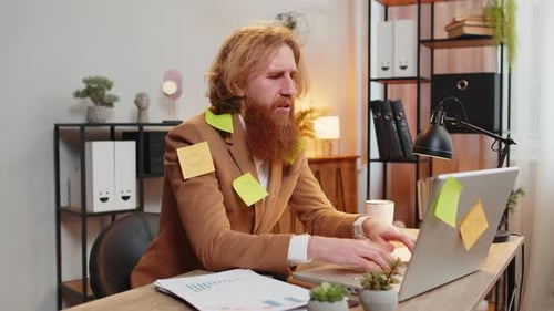 Tired Exhausted Frustrated Businessman Sits in Home Office Table with Laptop Sticky Notes Many Tasks