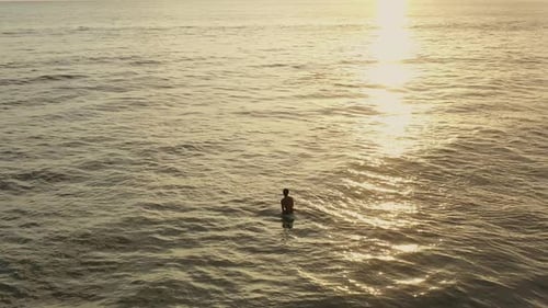 Man on Surfboard Waiting for Wave in the Sea