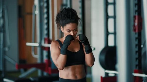 Frau übt Boxtechniken im Fitnessstudio mit Fokus auf Form und Technik