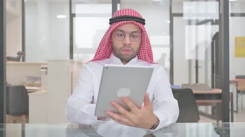 Joven musulmán que usa una tableta digital para trabajar