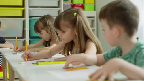 Children Study at Their Desks The Boy is Spying on the Girl's Task