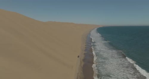 Aerial view of sandy dunes and ocean at Sandwich Harbour, Erongo, Namibia.