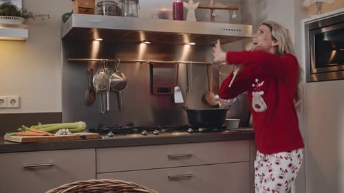 Woman Singing With Wooden Spoon in Kitchen