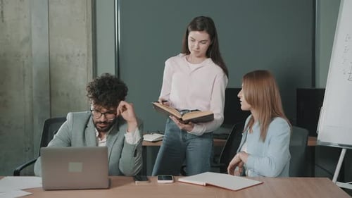 Team collaborates in office focusing on documents and discussions in slow motion