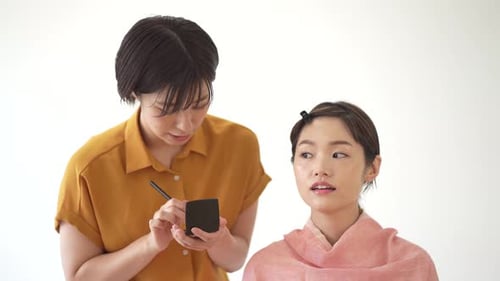 Makeup Artist Applying Makeup to Model Indoors