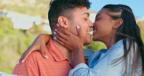 Kissing, hugging and laughing with a couple on the beach together for summer vacation