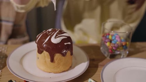A Closeup of a Decorated Easter Cake with Chocolate Icing As White Icing is Drizzled on Top with