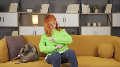 Woman Sitting on Couch Dancing and Smiling
