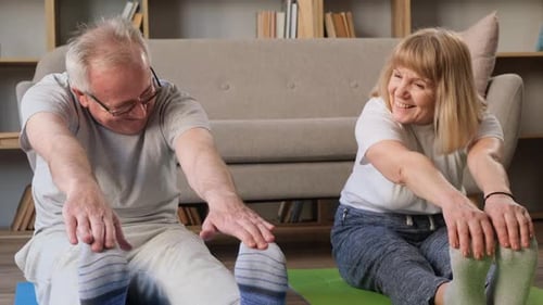 Smiling Senior Couple Stretching at Home