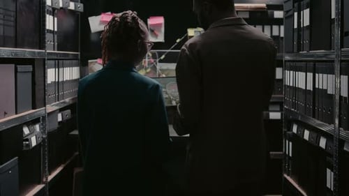 Investigators Reviewing Evidence in Dark File Room