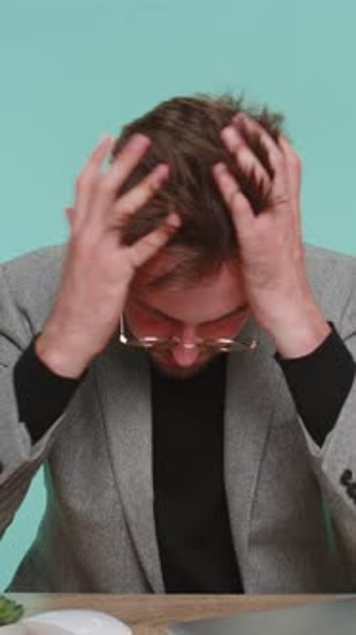 Man in Blazer Reacts to Bad News on Laptop