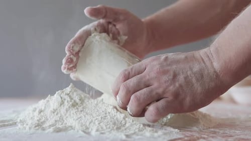 Close Up of Hands Mixing Flour on Table