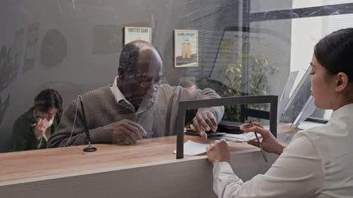 Senior African American Man Signing Documents in Modern Bank Office