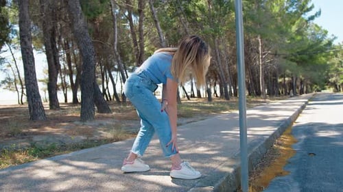 Woman Stretching Her Leg Near The Road