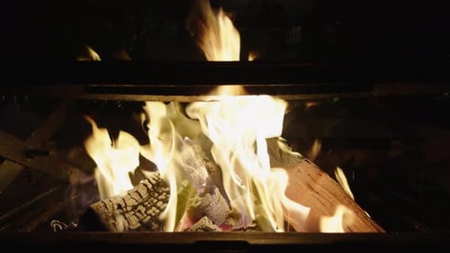 The firewood crackles as it burns with bright flames, perfect for grilling