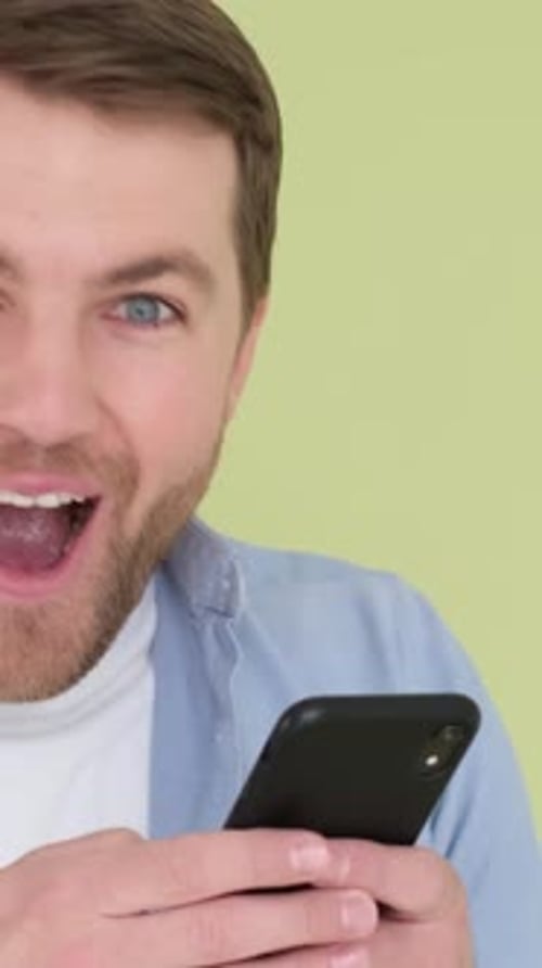Man Reacts Positively to Content on Cell Phone