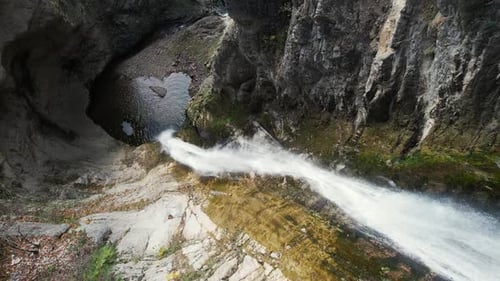 Aerial View of Waterfall Cascading Through Rocky Terrain