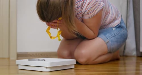 Woman Kneeling, Frustrated About Weight Loss