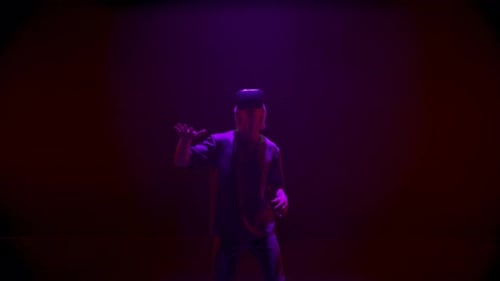 Man Uses VR Headset in Dark, Colorful Room