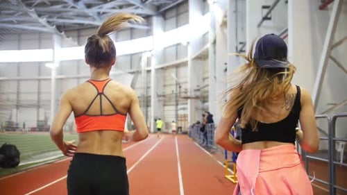 Fit Women Training and Running on an Indoor Track