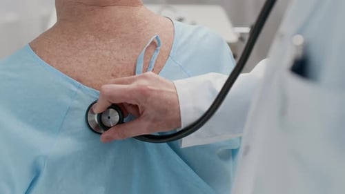 Anonymous Doctor Checking Elderly Patients Breathing with Stethoscope, Back View