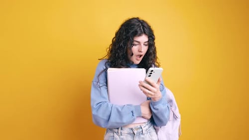 Young Woman Using Smartphone with Books