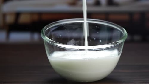 Milk being poured into a bowl