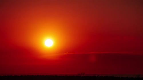 Zeitraffer des Sonnenuntergangs am orangefarbenen Himmel über dem Horizont