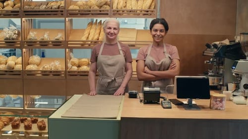 Two Female Cashiers Posing for Camera with Smile in Bakery