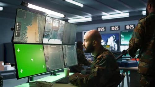 Army Soldier Looking at Chroma Key Screens in Command Center