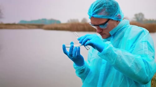 Scientist Analyzing Water Sample in Protective Gear