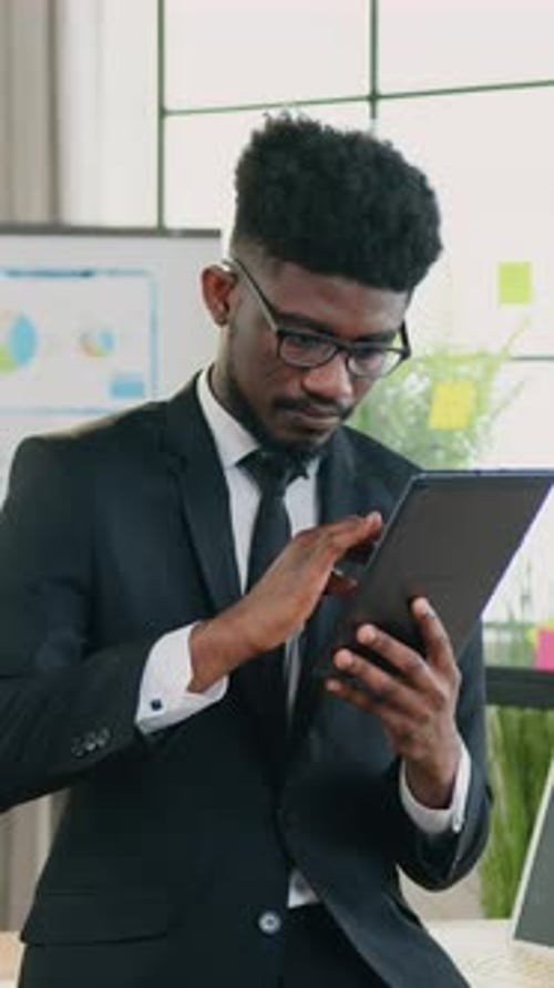 Focused Man in Suit Using Tablet in Office