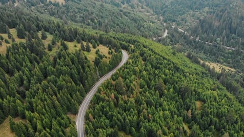 Cars Driving On A Country Road In Mountain Forest - aerial drone shot