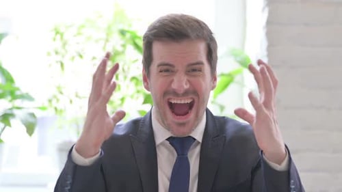 Angry Young Businessman Screaming in Frustration in Office