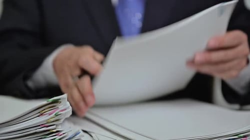 Man Writing on Paper Stack in Corporate Office