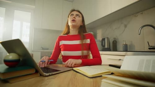 Tired Woman Studying at Home on Laptop