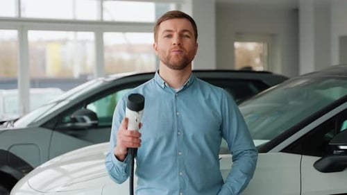 Handsome Man With Electric Car Charging Cable