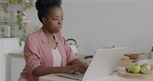 Woman Works on Laptop in Bright Kitchen