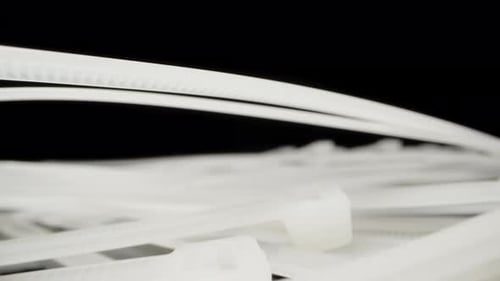 Las corbatas blancas de nylon caen sobre la mesa. Primer plano extremo de Dolly Slider. Sonda Laowa