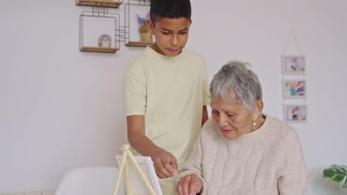 Teen Boy and Senior Woman Painting Together at Home