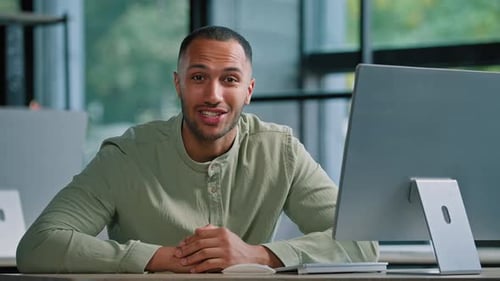 Young Man Talking at Desk with Computer