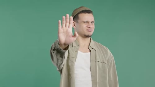 Young Man Holding Hand Up in Stop Gesture