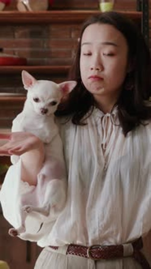 Woman Holding Small White Dog Indoors