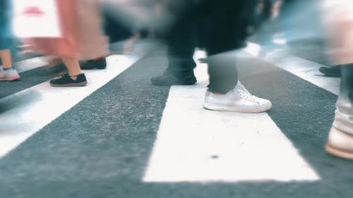 Crowd of people walk fast on busy urban street crosswalk time lapse