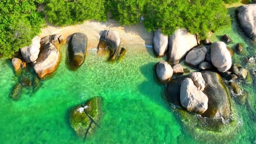 Stunning sandy beach with rock, clean sea water and green forest. 4K.